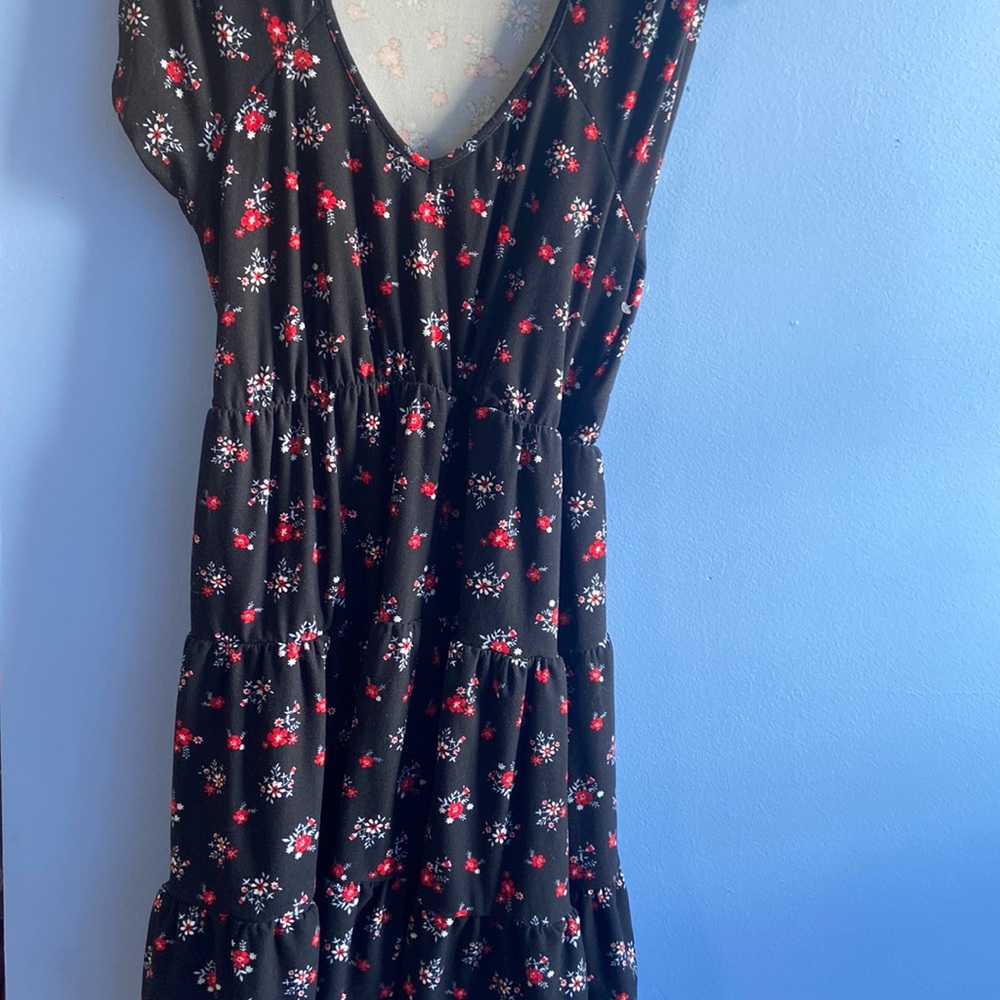 A black knee length dress with red flowers on it